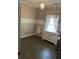 Bright bedroom featuring hardwood floors, white trim, and a chandelier, creating a cozy and elegant space at 10390 Rivertown Rd, Fairburn, GA 30213