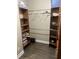 Bedroom closet with laminate flooring, built-in shelving, and hanging rod at 10390 Rivertown Rd, Fairburn, GA 30213