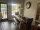 Inviting dining area with modern table, bench, stylish decor, large windows, and backyard views at 10390 Rivertown Rd, Chattahoochee Hills, GA 30213