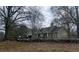Charming home exterior is surrounded by mature trees and lovely landscaping, offering a private setting at 10390 Rivertown Rd, Chattahoochee Hills, GA 30213