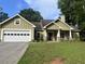 Charming one-story home featuring green siding, stone accents, and a well-manicured front lawn at 10390 Rivertown Rd, Fairburn, GA 30213