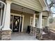 This exterior shows a beautiful porch with stone supports and updated lighting at 10390 Rivertown Rd, Chattahoochee Hills, GA 30213