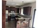 Well-equipped kitchen with dark cabinetry, granite countertops, and modern stainless steel appliances at 10390 Rivertown Rd, Fairburn, GA 30213