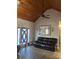 Living room with wooden ceiling and a black leather sofa at 10390 Rivertown Rd, Fairburn, GA 30213