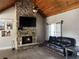 Cozy living room featuring a floor-to-ceiling stone fireplace and vaulted wood ceilings at 10390 Rivertown Rd, Fairburn, GA 30213