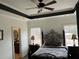 Bedroom with dark iron bed frame, ceiling fan, and windows at 10390 Rivertown Rd, Chattahoochee Hills, GA 30213