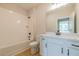 Bathroom features a shower-tub, white cabinets, modern faucet, and light countertop at 108 Redford Ln, Canton, GA 30115