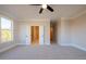 Spacious bedroom featuring neutral carpeting, a ceiling fan, and ample natural light from the large window at 108 Redford Ln, Canton, GA 30115