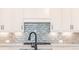 Bright kitchen showcasing backsplash, modern faucet, sleek cooktop, and white cabinetry at 108 Redford Ln, Canton, GA 30115