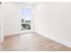 Minimalist bedroom with large window, hardwood floors, and white walls at 1171 Lupo Loop, Chattahoochee Hills, GA 30268