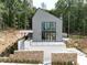 Stunning modern home with gray siding, large windows, and a stone retaining wall at 1171 Lupo Loop, Chattahoochee Hills, GA 30268