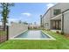 A backyard pool is surrounded by green grass and the home's exterior is clad in gray siding at 1171 Lupo Loop, Chattahoochee Hills, GA 30268