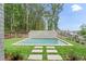 Backyard pool features a modern design, concrete surround, and lush green grass at 1171 Lupo Loop, Chattahoochee Hills, GA 30268
