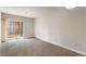 An empty living room, with neutral walls, carpet floors and a sliding door to a balcony at 195 14Th Ne St # 1404, Atlanta, GA 30309