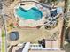 Aerial view of a backyard oasis, featuring a kidney-shaped pool, firepit, and lush landscaping at 3530 Horizon Ct, Cumming, GA 30041