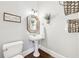 Charming half-bathroom with pedestal sink, unique mirror, and humorous wall art, adding character at 3530 Horizon Ct, Cumming, GA 30041