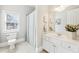 Bathroom features a white vanity, mirror, sink, toilet, window, white walls, tiled floors and a shower at 3530 Horizon Ct, Cumming, GA 30041