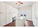Bonus room features an island, a built-in desk, white cabinets, hardwood floors and doors leading to a patio at 3530 Horizon Ct, Cumming, GA 30041