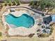 Aerial view of a kidney-shaped pool surrounded by a stone patio, outdoor seating, and a fire pit at 3530 Horizon Ct, Cumming, GA 30041