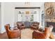 Sitting area with stone fireplace, built in cabinets and four leather arm chairs at 3530 Horizon Ct, Cumming, GA 30041