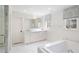 Bright white bathroom features marble floors, dual vanity, and soaking tub at 39 Paces West Nw Dr, Atlanta, GA 30327