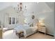 Cozy bedroom with a vaulted ceiling, a chandelier, soft carpeting, and a comfortable bed at 39 Paces West Nw Dr, Atlanta, GA 30327