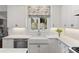 Bright kitchen featuring a farmhouse sink, white cabinets, and stylish window treatments at 39 Paces West Nw Dr, Atlanta, GA 30327