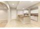 Bright kitchen view featuring tiled floors, breakfast bar, and white cabinets with a view to an adjacent carpeted area at 4089 Hooch River Trl, Suwanee, GA 30024