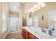 Bathroom featuring double sink vanity, large mirror, and glass enclosed shower at 9246 W Banks Mill Rd, Winston, GA 30187