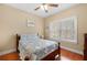 Cozy bedroom with ceiling fan, hardwood floors, and natural light from the large window at 9246 W Banks Mill Rd, Winston, GA 30187