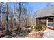 Home exterior with screened porch, stone retaining wall and treed lot at 9246 W Banks Mill Rd, Winston, GA 30187