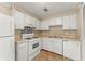 Cozy kitchen featuring white appliances, tile backsplash, and ample cabinet space at 7613 Suwannee Ct, Jonesboro, GA 30236