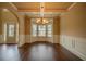 Bright dining room showcasing a decorative chandelier, wainscoting, and bay window at 85 Providence Pkwy, Covington, GA 30014