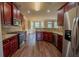 Modern kitchen with stainless steel appliances, granite countertops, and cherry wood cabinets at 85 Providence Pkwy, Covington, GA 30014