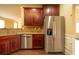 Kitchen featuring stainless steel refrigerator, dark wood cabinets, and granite countertops at 85 Providence Pkwy, Covington, GA 30014