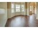 Sunlit living room with dark hardwood floors, a bay window, and elegant trim work at 85 Providence Pkwy, Covington, GA 30014