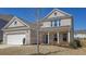 Inviting two-story home with brick facade, a two-car garage, and a covered front porch at 1236 Maston Rd, Auburn, GA 30011