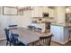 A kitchen featuring white cabinets, stainless steel appliances, and a long gray dining table with 6 chairs at 1236 Maston Rd, Auburn, GA 30011