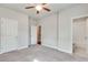 Neutral bedroom with gray carpet flooring, a ceiling fan and an ensuite bathroom, all complemented by natural light at 145 Laurel Crest Aly, Johns Creek, GA 30024