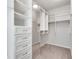 Walk-in closet featuring custom shelving, drawers and carpeted floor at 145 Laurel Crest Aly, Johns Creek, GA 30024