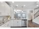 Kitchen island with stainless steel dishwasher, sink and gooseneck faucet and view to dining and living area at 145 Laurel Crest Aly, Johns Creek, GA 30024