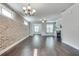 Spacious living room features hardwood floors, brick wall, chandelier, and ceiling fan at 145 Laurel Crest Aly, Johns Creek, GA 30024