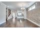 Spacious living room boasting hardwood floors, an exposed brick wall, and stairs at 145 Laurel Crest Aly, Johns Creek, GA 30024