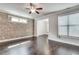 Bright living room with brick wall, hardwood floors, recessed lighting, and large windows at 145 Laurel Crest Aly, Johns Creek, GA 30024