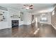 Open concept living area with fireplace, built in shelving, kitchen, and hardwood floors at 145 Laurel Crest Aly, Johns Creek, GA 30024