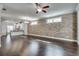 Living area with brick wall, hardwood floors, recessed lighting, and view to kitchen at 145 Laurel Crest Aly, Johns Creek, GA 30024