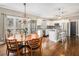 Open-concept kitchen and dining area featuring hardwood floors, modern appliances, and a large table at 358 Woodbrook Crst, Canton, GA 30114