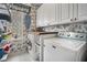 Efficient laundry room featuring front load washer/dryer, white cabinets, wood countertop and tile floors at 358 Woodbrook Crst, Canton, GA 30114