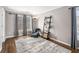 Cozy sitting room with decorative ladder shelving, hardwood floors, a patterned rug, and many large windows at 358 Woodbrook Crst, Canton, GA 30114