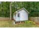 Exterior view of a charming backyard shed with a blue door, surrounded by trees and greenery at 2653 Hatfield Se Cir, Atlanta, GA 30316